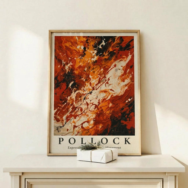 May include: Abstract expressionist artwork in warm orange, red, and black swirling paint strokes displayed in a light wood frame on a white wall. The framed print sits on a pale wooden console table next to a small white gift box with green botanical decoration. The painting features dynamic fluid movements and bold contrasting colors in an energetic composition.