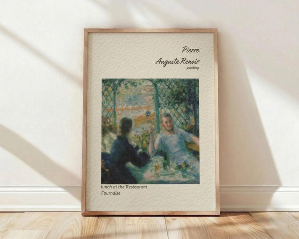 May include: Framed art print of Renoir's impressionist painting showing two figures dining at a restaurant terrace with green lattice work and foliage. The poster features soft brushstrokes in blues, greens, and warm tones, displayed in a light wood frame with cream matting, leaning against white wall on blonde hardwood floor with natural window light creating shadows.