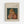 May include: Framed art print on wall showing Renoir painting of young girl with reddish hair and yellow bow sewing white fabric. Girl wears pink dress against dark teal background. Print has cream matting with text identifying Pierre Auguste Renoir and "Jean Renoir sewing" in light wooden frame.