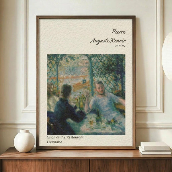 May include: Framed reproduction of Renoir's impressionist painting showing people dining at a restaurant, with soft blues and greens dominating the scene. The wooden-framed print sits on a wood sideboard next to a white ceramic vase and books, against cream wainscoted walls. The artwork features the characteristic loose brushwork and dappled light of the Impressionist style, depicting figures seated around a table in an outdoor restaurant setting.
