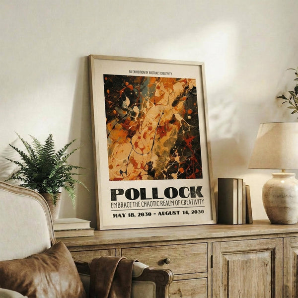 May include: Abstract art poster with warm autumn colors - oranges, yellows, and dark greens in chaotic splattered paint style, displayed in light wood frame on rustic wooden sideboard. Room scene shows cream upholstered chair, potted fern, ceramic vase, stacked books, and soft natural lighting against white walls.