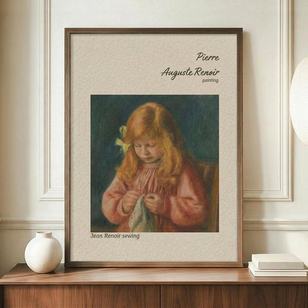 May include: Framed reproduction of Renoir painting showing young girl with reddish hair and yellow bow concentrating on needlework, wearing coral-pink dress against dark teal background. Print has cream matting in brown wooden frame, displayed on walnut sideboard beside white ceramic vase and stacked books in elegant room with white wainscoting.