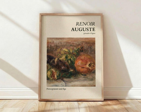 May include: A framed art print leaning against a white wall on light wooden flooring. The poster features a classical still life painting of pomegranates and figs in warm oranges, greens, and browns with visible brushstrokes. The artwork is displayed in a thin wooden frame with cream matting. Text reads "RENOIR AUGUSTE" at the top and "Pomegranate and figs" at the bottom. Soft natural light creates diagonal shadows across the white textured wall.