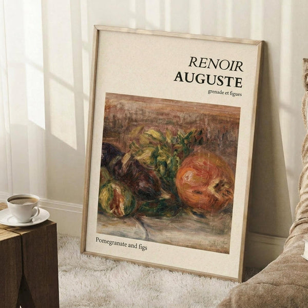 May include: Framed art print leaning against white wall corner on textured cream rug. Light wood frame contains vintage-style still life painting of pomegranate and figs in warm earth tones with green foliage. White coffee cup on wooden block sits nearby. Beige fabric draped in corner. Natural lighting creates soft shadows on white walls.