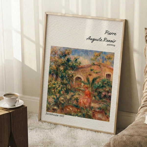 May include: Framed poster print of an impressionist painting showing a figure in red clothing sitting in a lush garden landscape with warm earth tones, greens, and a rustic building in the background. The print is displayed in a light wooden frame, leaning against a white wall next to a beige armchair, with a coffee cup on a wooden side table and white textured rug beneath.