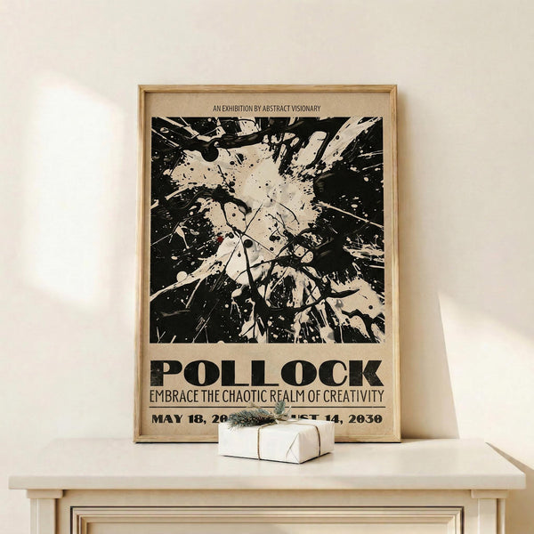 May include: Framed vintage-style exhibition poster featuring black and cream abstract paint splatter artwork reminiscent of Jackson Pollock's style, with bold "POLLOCK" text and "Embrace the Chaotic Realm of Creativity" tagline. Light wood frame displayed on cream wooden shelf beside small white gift box with evergreen sprig against neutral wall.