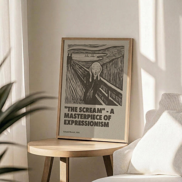 May include: Black and white reproduction of Edvard Munch's The Scream artwork displayed in thin wood frame on round wooden side table next to beige upholstered chair. Poster shows iconic figure with hands to face on bridge with swirling sky, includes text identifying it as masterpiece of expressionism. Soft natural lighting creates shadows across neutral-toned modern interior with plant visible in corner.