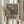 May include: Person in cream sweater holding framed poster of The Scream artwork by Edvard Munch from 1895. Black line drawing on beige paper shows iconic screaming figure on bridge with wavy sky. Dried pampas grass visible to left, soft natural lighting against white curtained background.