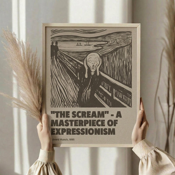 May include: Person in cream sweater holding framed poster of The Scream artwork by Edvard Munch from 1895. Black line drawing on beige paper shows iconic screaming figure on bridge with wavy sky. Dried pampas grass visible to left, soft natural lighting against white curtained background.
