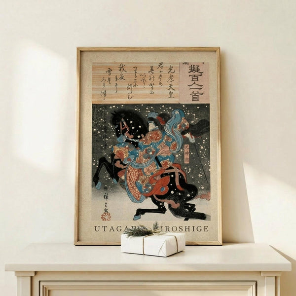 May include: Framed Japanese woodblock print featuring a warrior in ornate armor with flowing blue hair amid swirling snow or petals against a dark background. The artwork has Japanese calligraphy at the top and sits on a light wood shelf next to a small white wrapped gift with greenery. The frame appears natural wood colored against a cream wall.