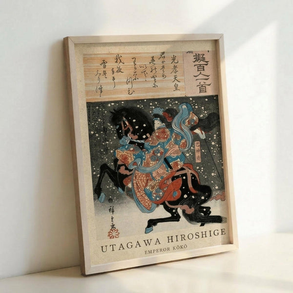 May include: Framed Japanese woodblock print featuring a figure in colorful traditional robes with flowing blue ribbons against a dark background with white dots resembling snow. The artwork shows intricate details in orange, blue, and red tones, with Japanese text at the top and English text at bottom identifying the artist and subject. Light wooden frame displayed against white wall.