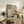May include: Japanese-inspired abstract art print with geometric shapes, red sun circle, and pine branch elements displayed in light wood frame on rustic wooden sideboard alongside fern plant, ceramic vase, and books in neutral-toned living room setting