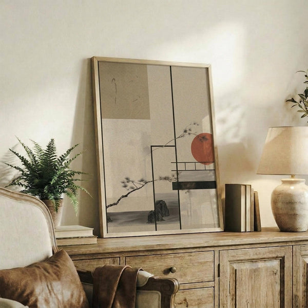 May include: Japanese-inspired abstract art print with geometric shapes, red sun circle, and pine branch elements displayed in light wood frame on rustic wooden sideboard alongside fern plant, ceramic vase, and books in neutral-toned living room setting