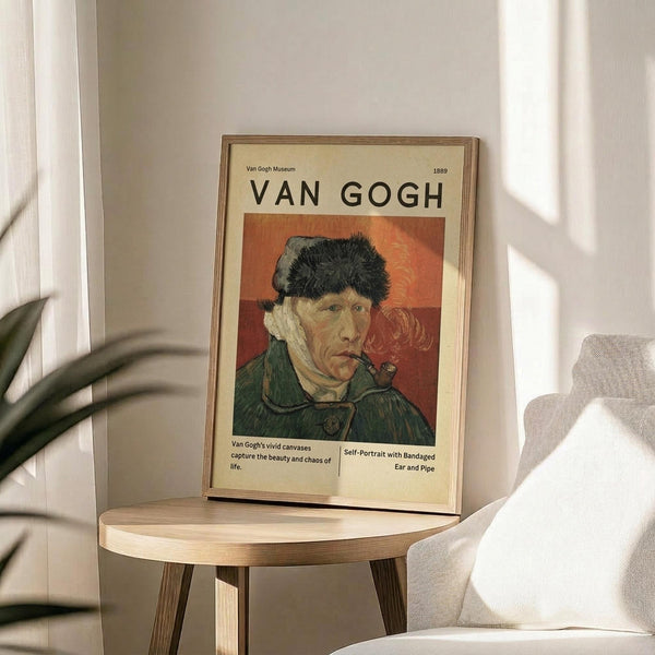 May include: Framed Van Gogh museum poster displaying his self-portrait with bandaged ear and pipe, featuring warm orange background and green jacket. The vintage-style print sits on a round wooden stool beside a beige upholstered chair, with plant leaves visible in soft natural lighting against white walls.