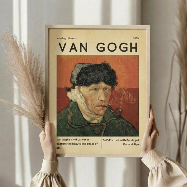 May include: Person in cream clothing holds framed Van Gogh museum poster featuring self-portrait with bandaged ear and pipe. Poster shows artist in green coat and fur hat against orange-red background. Cream-colored frame and pampas grass visible in soft, neutral-toned room setting.