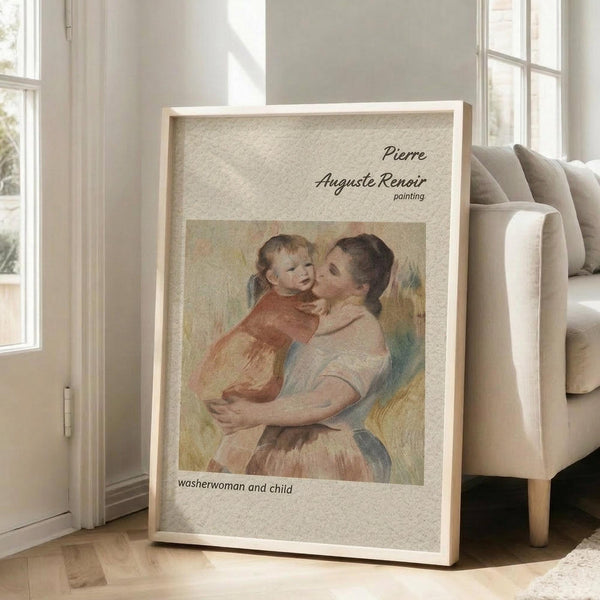 May include: Framed art print leaning against beige armchair in bright living room with white walls and windows. Print shows Renoir's soft pastel painting of woman in white dress holding blonde child in red clothing, with text identifying artist and artwork title. Natural wood frame, textured cream matting.