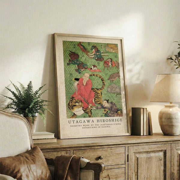 May include: Framed Japanese woodblock print featuring figures in colorful robes with tigers and other animals on green geometric background, displayed on rustic wooden sideboard alongside fern plant, ceramic vase, and books in neutral-toned living room setting with beige upholstered furniture