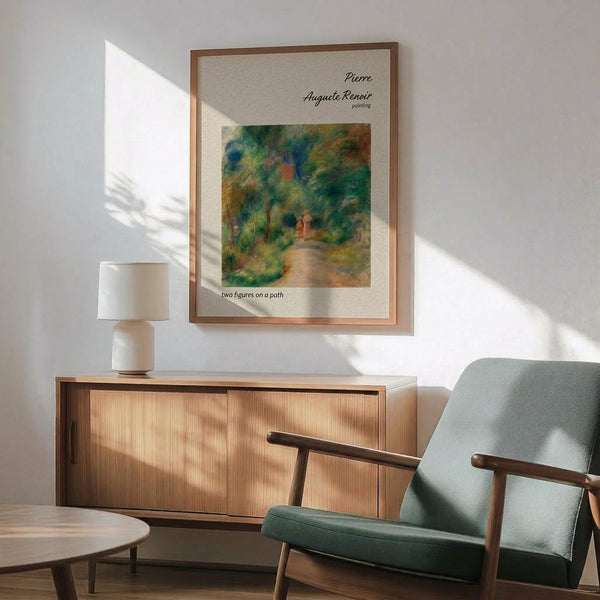 May include: Framed Renoir reproduction print showing impressionist landscape painting with two figures on garden path surrounded by lush green foliage. Print displayed above mid-century modern wood credenza next to ceramic table lamp, with mint green upholstered armchair in foreground. Warm natural lighting creates geometric shadows on white wall.