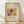 May include: Framed art print featuring Wassily Kandinsky's abstract Rain Landscape painting with flowing organic forms in red, yellow, blue, and earth tones against cream background. Wooden frame leans against white wall on light wood floor with soft natural lighting creating diagonal shadows.