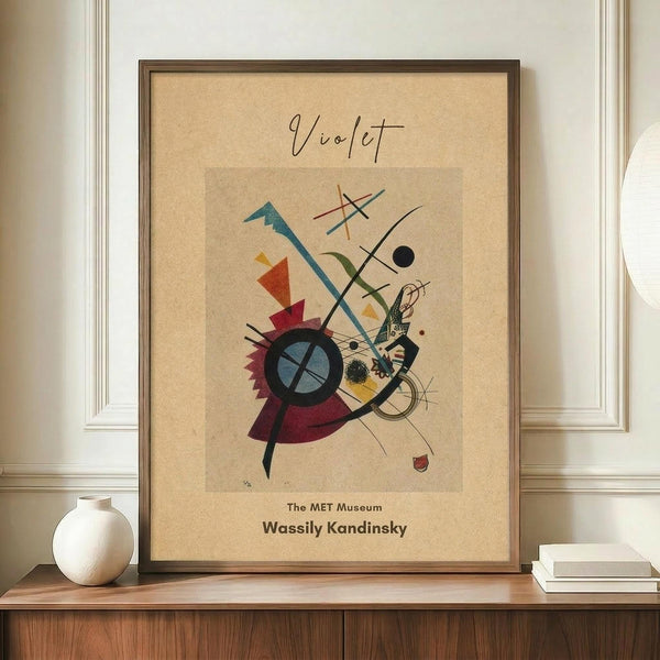 May include: Abstract modernist artwork in wooden frame on wooden sideboard next to white ceramic vase and books. The framed piece features geometric shapes, lines, and forms in vibrant colors including teal, red, yellow, and purple on beige background. Museum-style poster with text attribution below the colorful abstract composition. Interior setting shows neutral walls with white trim molding.
