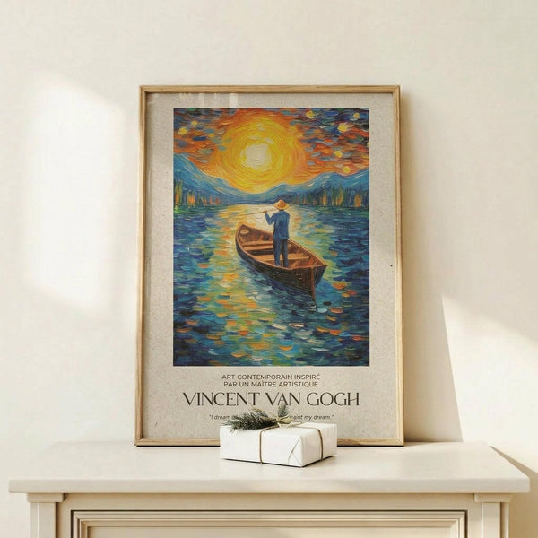 May include: Framed art print displayed on light wood shelf against cream wall, showing figure standing in wooden boat on water with swirling golden sun and starry sky in Van Gogh's distinctive brushstroke style. Text below reads "Vincent Van Gogh" with French subtitle. Small wrapped gift box with twine sits beside the natural wood frame.