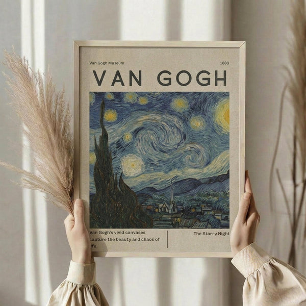 May include: Person in cream blouse holding framed Van Gogh museum poster featuring The Starry Night painting with swirling blue sky and yellow stars. Natural wood frame, beige mat, dried wheat stems visible. Soft window lighting creates gentle shadows on neutral wall background.