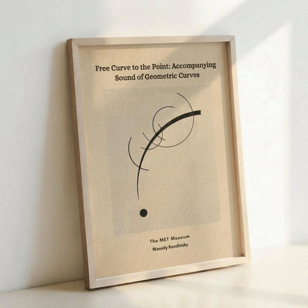 May include: Framed minimalist art print featuring abstract black curved lines and geometric shapes including circles and a dot on cream-colored paper, displayed in light wood frame leaning against white wall on light surface