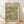 May include: Framed vintage William Morris exhibition poster featuring intricate green and cream floral pattern with flowing botanical designs. The Arts and Crafts style artwork shows detailed flowers, leaves and vines against sage green background. Wooden frame leans against white wall on light wood floor with soft natural lighting creating diagonal shadows across the scene.
