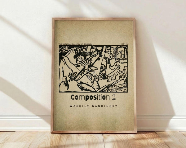 May include: Framed vintage poster print featuring Wassily Kandinsky's abstract black ink composition on aged beige paper background. The artwork shows dynamic flowing forms and organic shapes in an expressionist woodcut style. Simple wooden frame sits on light wood floor against white wall with soft natural lighting creating diagonal shadows across the scene.