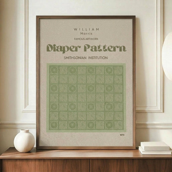 May include: Framed poster with beige background displaying green geometric diaper pattern in grid layout, attributed to William Morris and Smithsonian Institution, dated 1870. Wood frame sits on wooden sideboard next to white ceramic vase and stacked books against cream wainscoted wall.