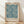 May include: A framed art print featuring an intricate blue and cream botanical pattern with marigold flowers, ferns, and foliage in William Morris's distinctive Arts and Crafts style. The print is displayed in a light wood frame, leaning against a white wall on natural wood flooring with soft natural lighting creating gentle shadows.