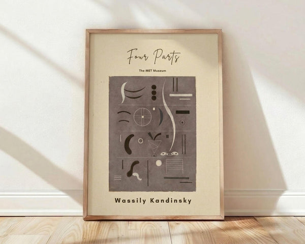May include: Framed abstract art print with geometric shapes, lines, and symbols in muted brown tones on cream background, displayed in light wood frame against white wall on wooden floor with soft natural lighting and shadows