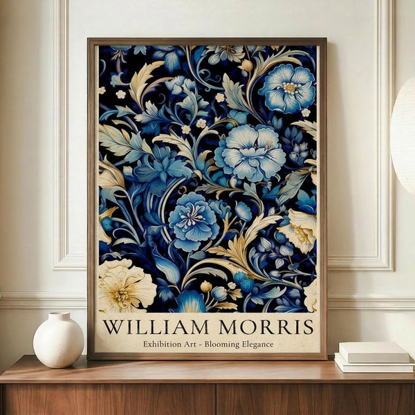 May include: Framed art poster featuring intricate blue and cream floral pattern with ornate blooms and scrolling foliage on dark background, displayed on wooden sideboard next to white ceramic vase and stacked books in elegant room with cream walls and white molding