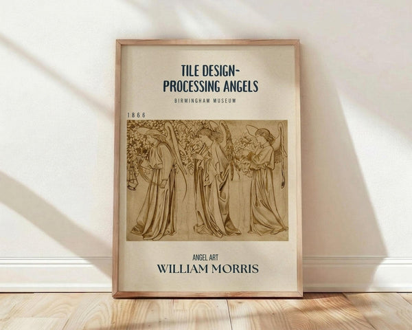 May include: Framed vintage poster with cream background displaying sepia-toned illustration of three flowing robed angels with wings, titled "Tile Design-Processing Angels" from Birmingham Museum 1866, credited to William Morris, leaning against white wall on light wood floor with soft natural lighting and shadows