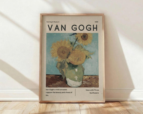 May include: Framed Van Gogh sunflower poster in light wood frame leaning against white wall on wooden floor. Print features three golden sunflowers in green ceramic vase against turquoise background. Museum-style design with "VAN GOGH" text at top, year 1888, and descriptive text below artwork. Soft natural lighting creates diagonal shadows across the scene.