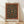 May include: Framed poster print featuring an ornate Victorian carpet design with intricate floral patterns on a dark teal background, surrounded by a decorative red and gold border. The artwork displays swirling botanical motifs with orange and rust-colored flowers throughout. Light wooden frame rests against a white wall on natural wood flooring, with soft natural lighting creating gentle shadows.