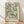 May include: Framed botanical art print featuring flowing green and cream leaves in William Morris-inspired pattern, displayed in light wood frame against white wall with natural window lighting casting soft shadows on wooden floor.