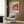 a cozy living room with a white armchair, a floor lamp, and a framed poster of a floral design on the wall.