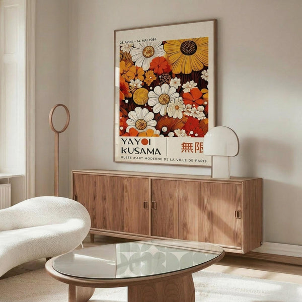 a living room with a large floral poster on the wall, a wooden cabinet, a white sofa, and a glass coffee table.