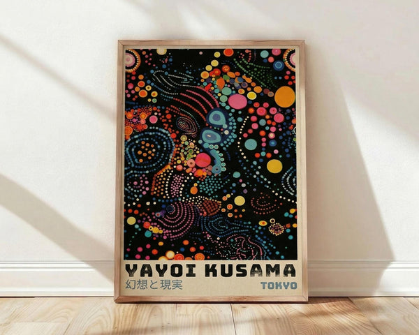 May include: Framed poster with vibrant abstract dot art on black background, featuring swirling patterns of colorful circles in orange, pink, blue, yellow, and green. Text reads "YAYOI KUSAMA" and "TOKYO" in bold letters below the psychedelic dotted design. Natural wood frame leaning against white wall on light wooden floor with soft shadows.