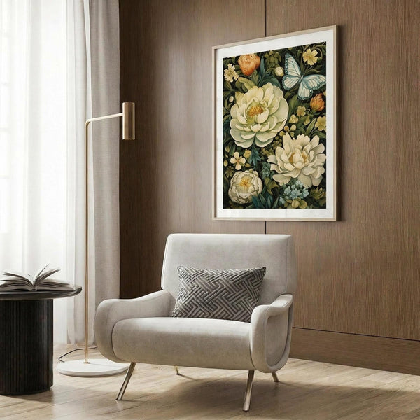 May include: Framed botanical art print with white and cream flowers, blue butterfly, and dark green foliage displayed on wood-paneled wall above beige upholstered armchair with geometric pillow, brass floor lamp and side table with open book nearby