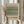 May include: Hands holding a framed vintage botanical print featuring an intricate green and cream floral pattern with tulip motifs in an ornate Victorian style. The artwork is displayed in a light wood frame against soft neutral curtains, with dried pampas grass visible to the side, creating a minimalist aesthetic room setting.