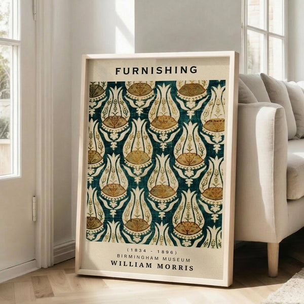May include: Framed poster with ornate Victorian wallpaper pattern in teal, cream and gold tones featuring repeated decorative motifs. White wooden frame leans against bright living room wall next to beige upholstered sofa. Natural sunlight streams through large windows creating soft shadows on hardwood floors.