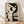 May include: Framed abstract art print leaning against white wall on light wood floor. The poster features a stylized woman's profile in black and cream tones with geometric shapes including circles, crescents, and lines. Natural wood frame surrounds the minimalist design. Soft shadows cast across the scene from natural lighting.