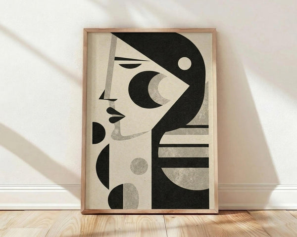 May include: Framed abstract art print leaning against white wall on light wood floor. The poster features a stylized woman's profile in black and cream tones with geometric shapes including circles, crescents, and lines. Natural wood frame surrounds the minimalist design. Soft shadows cast across the scene from natural lighting.