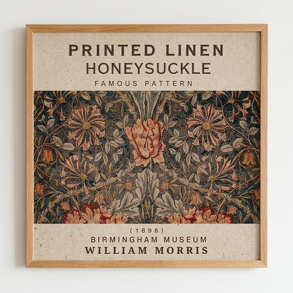 Framed museum poster displaying William Morris's intricate Honeysuckle pattern from 1896. The design features ornate botanical motifs with large stylized flowers and foliage in rich jewel tones of deep blue, coral pink, golden yellow, and sage green against a dark background. The artwork is surrounded by cream-colored text identifying it as "Printed Linen Honeysuckle Famous Pattern" from Birmingham Museum. Natural wood frame against white wall.