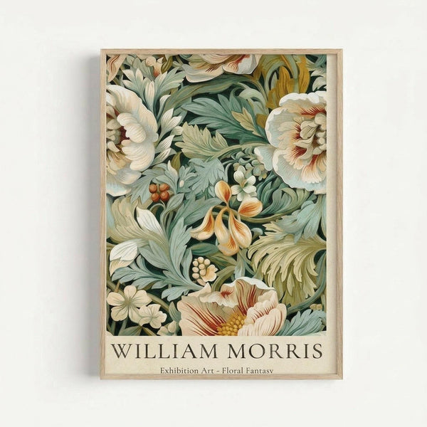 A framed botanical art print featuring an intricate floral pattern with cream and white flowers, sage green foliage, and orange accents in William Morris's distinctive Arts and Crafts style. The artwork displays flowing, organic forms with detailed leaves and blooms against a darker background. Below the illustration, text reads "WILLIAM MORRIS Exhibition Art - Floral Fantasy" on a cream-colored border. The print is displayed in a light wooden frame against a white wall.