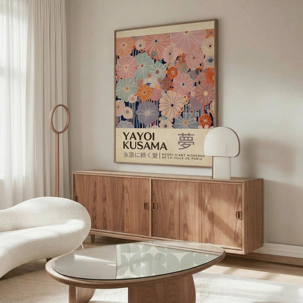 May include: Colorful floral art poster with overlapping circular flower patterns in pink, orange, blue, and green tones, displayed in wooden frame above mid-century modern walnut credenza. Modern living room setting features white curved chair, glass oval coffee table, floor lamp, and neutral walls with natural lighting from curtained window.