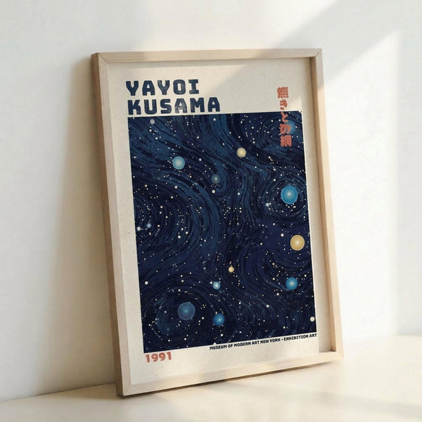 May include: Framed art print leaning against white wall showing dark navy blue swirling pattern with colorful polka dots in blues, yellows, and greens scattered throughout. Text reads "YAYOI KUSAMA" at top with Japanese characters and "1991" at bottom. Light wood frame with white matting, Museum of Modern Art attribution visible.