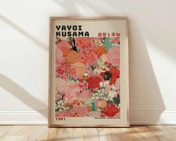 May include: Framed art print featuring Yayoi Kusama's signature polka dot pattern in vibrant colors including coral, pink, orange, mint green, and red circular shapes with various textures and patterns. The poster displays "YAYOI KUSAMA" in bold black letters at top with Japanese characters, dated 1981, and gallery exhibition text at bottom. Shown in thin wooden frame leaning against white wall on light wooden floor with soft natural lighting creating gentle shadows.
